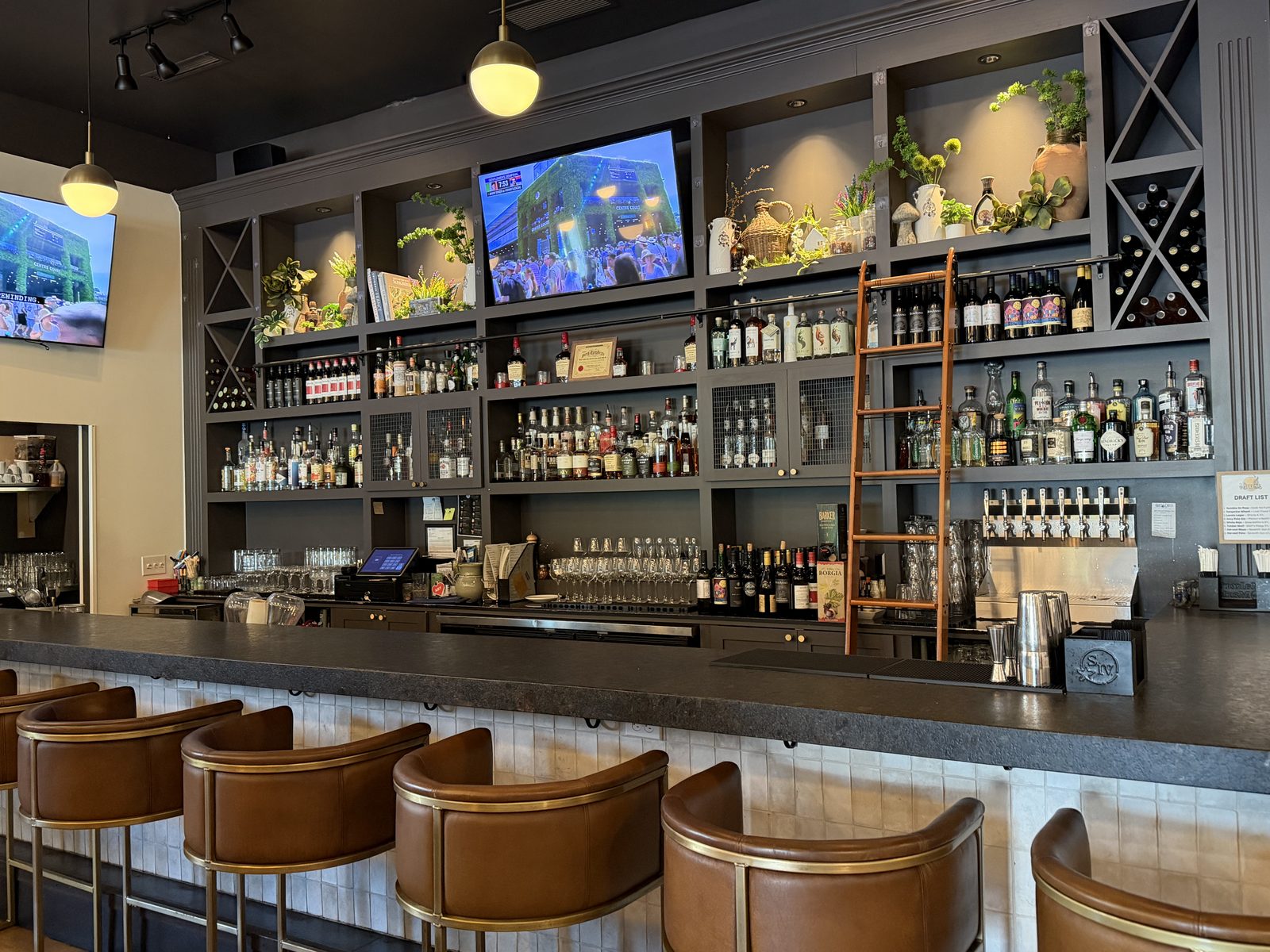 Harvest Granville bar with leather barrel stools, backlit spirits shelves, and draft taps